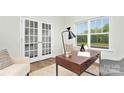Bright office space with a modern desk, chair, rug and French doors at 11135 Cardinal Creek Ave, Charlotte, NC 28215
