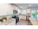 Well-lit kitchen featuring white cabinets, granite countertops, and stainless steel appliances at 11216 Cardinal Creek Ave, Charlotte, NC 28215
