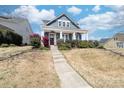 Attractive blue two-story house featuring a covered front porch and well-maintained lawn at 120 Keats Aly, Cramerton, NC 28032