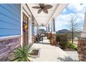Inviting front porch with stone pillars, ceiling fans, and comfortable seating area at 120 Keats Aly, Cramerton, NC 28032
