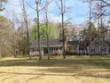 Charming gray home with a brick chimney, well-maintained lawn, and surrounded by mature trees at 1414 Farmstead Rd, Rock Hill, SC 29732