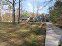 Expansive front yard and long driveway leading to a charming gray home, perfect for Gathering living at 1414 Farmstead Rd, Rock Hill, SC 29732
