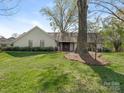 Beautiful white brick home with mature trees and green lawn at 3301 Mountainbrook Rd, Charlotte, NC 28210