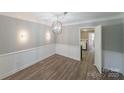 Elegant dining room featuring modern floors, wainscoting, and a stylish chandelier, ideal for memorable dining experiences at 4351 Woodglen Ln, Charlotte, NC 28226