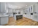 Spacious kitchen featuring white cabinetry, a large island, and modern lighting at 463 Lake Wylie Rd, Belmont, NC 28012