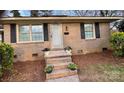 Close-up of a charming brick house featuring a welcoming front door and landscaped entryway at 4805 Horizon Cir, Charlotte, NC 28215