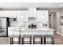 Modern kitchen featuring white cabinets, stainless steel appliances, granite countertops, and a spacious island with seating at 510 Kenyon Dr, Denver, NC 28037