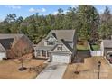 An aerial view showcases a charming two-story home with a lush treeline and a private backyard at 5813 Mcclintock Dr, Denver, NC 28037
