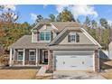 Attractive two-story home with a stone-accented facade, a two-car garage, and well-maintained landscaping at 5813 Mcclintock Dr, Denver, NC 28037