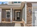 Inviting front porch features stacked stone accents, comfortable seating, and a stylish front door at 5813 Mcclintock Dr, Denver, NC 28037