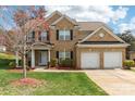 Beautiful two-story brick home with green lawn, flower beds and two-car garage at 9391 Leyton Dr, Harrisburg, NC 28075