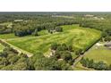 Lush aerial view of expansive green property with scattered trees, access roads and houses nestled amongst the greenery at Lot 14 Mayes Meadow Dr, Cornelius, NC 28078