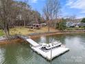 Wide view of a private boat dock on the water, and a well-maintained lawn leading to the house at 116 Cottage Grove Ln, Mooresville, NC 28117