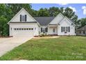 Charming white home with a two-car garage, pretty landscaping and an inviting entryway at 145 Mcbride Dr, Rockwell, NC 28138