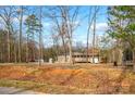 View of the exterior of the house amongst bare trees at 153 Cheshire Ridge Rd, Harmony, NC 28634