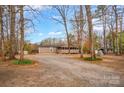 Quaint single-story home featuring a screened-in porch and surrounded by a lush wooded landscape at 153 Cheshire Ridge Rd, Harmony, NC 28634