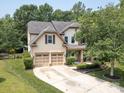 Beautiful exterior showcasing a well-maintained lawn, a two-car garage, and a charming front porch at 1800 Robbins Meadows Dr, Waxhaw, NC 28173
