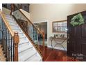 Grand foyer with hardwood floors, a staircase with iron railings, and stylish entryway decor at 1800 Robbins Meadows Dr, Waxhaw, NC 28173