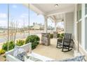 Relaxing covered porch featuring comfortable seating, stone pillars, and a view of the neighborhood at 2150 Paddlers Cove Dr, Clover, SC 29710