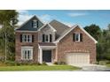 A brick two-story home is complimented by stone, an attached garage and professional landscaping at 3041 Tramore Dr, Harrisburg, NC 28075