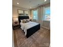Comfortable bedroom featuring two windows, a patterned rug, and two bedside tables with lamps at 317 Maidstone Dr # 57, Monroe, NC 28110