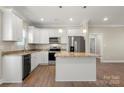 Well-lit kitchen with white cabinetry, granite countertops, stainless steel appliances, and a kitchen island at 325 East St, Heath Springs, SC 29058