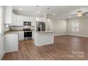 Modern kitchen featuring white cabinets, stainless steel appliances, and a central island with granite countertops at 325 East St, Heath Springs, SC 29058