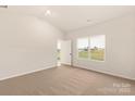 A bedroom with carpet, light walls, a ceiling light, and a window overlooking the lawn at 3324 Burberry Dr, Gastonia, NC 28052