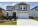 Charming two-story home with a two-car garage, blue door, manicured lawn and stone accents at 346 Knotty Wood Dr # 71, Monroe, NC 28110