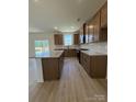 Modern kitchen featuring stainless steel appliances, granite countertops, a central island, and wood-finished cabinets at 346 Knotty Wood Dr # 71, Monroe, NC 28110