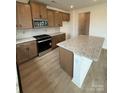 Kitchen showing wood cabinets, granite countertops, stainless steel appliances, tile backsplash, and large island at 346 Knotty Wood Dr # 71, Monroe, NC 28110
