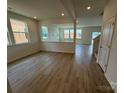 Spacious, light-filled open-concept living room with wood floors and large windows overlooking the neighborhood at 346 Knotty Wood Dr # 71, Monroe, NC 28110