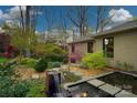 Picturesque backyard featuring a zen water feature surrounded by beautiful landscaping at 4313 Kingswood Rd, Charlotte, NC 28226