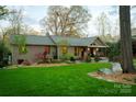 Beautiful front exterior with mature trees, inviting front porch, and manicured lawn at 4313 Kingswood Rd, Charlotte, NC 28226