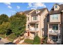 Attractive brick townhome with multiple stories and balconies, set against a clear blue sky at 735 Amalfi Dr, Davidson, NC 28036