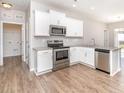 Modern kitchen with stainless steel appliances, granite countertops, and white cabinets at 10500 Bradstreet Commons Way, Charlotte, NC 28215