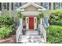 Inviting front porch featuring a vibrant red door, hanging ferns, and decorative planters at 11 Tanglewood Rd, Lake Wylie, SC 29710