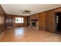 Inviting living room with wood-paneled walls, brick fireplace, and ample natural light at 126 Regal Cir # 2122, Mooresville, NC 28115