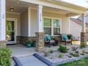 Inviting front porch with stone pillars and seating, offers a cozy outdoor space, and enhances curb appeal at 1512 Brooksland Pl, Waxhaw, NC 28173