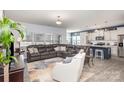 Open-concept living area showcases a modern design, featuring a large sectional sofa and seamlessly connecting to the kitchen at 1512 Brooksland Pl, Waxhaw, NC 28173