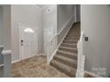 Bright foyer with tile flooring, staircase with white railing, and two entry doors at 155 Gray Cliff Dr, Mooresville, NC 28117