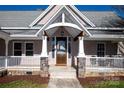 Charming covered front porch with stone supports, white columns, and a wood door at 1615 Stack Rd, Monroe, NC 28112