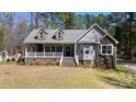 Inviting two-story home features a cozy front porch, stone accents, dormers, and well-manicured front yard at 1717 Deer Run Rd, Catawba, SC 29704