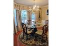 Elegant dining room featuring a chandelier, decorative rug and wooden chairs at 1912 Darbywine Dr, Charlotte, NC 28216