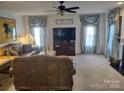 Bright living room with a fireplace, ceiling fan, and comfortable seating at 1912 Darbywine Dr, Charlotte, NC 28216