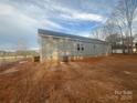 The home's backyard with gray vinyl siding, a small wooden deck and visible HVAC unit at 2070 Travis Rd, Conover, NC 28613