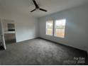 A carpeted bedroom with large windows and a ceiling fan at 2070 Travis Rd, Conover, NC 28613