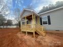 Newly constructed wooden front porch with steps leading to the entrance of this cozy gray home at 2070 Travis Rd, Conover, NC 28613
