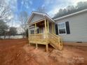 New front porch with wooden railings and gray siding at 2070 Travis Rd, Conover, NC 28613