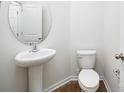 Stylish half bathroom featuring a pedestal sink, oval mirror, and modern fixtures at 3168 Ora Smith Rd, Lincolnton, NC 28092